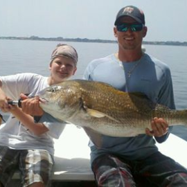 Boy and man holding fish