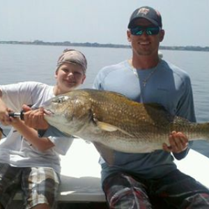 Boy and man holding fish