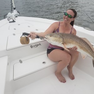 a person holding a fish on a boat in the water