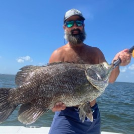 a man holding a fish in the water
