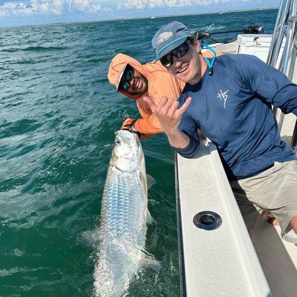 a man holding a fish in the water