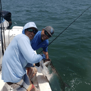 a man holding a fish in the water