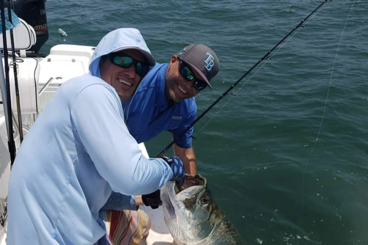a man holding a fish in the water