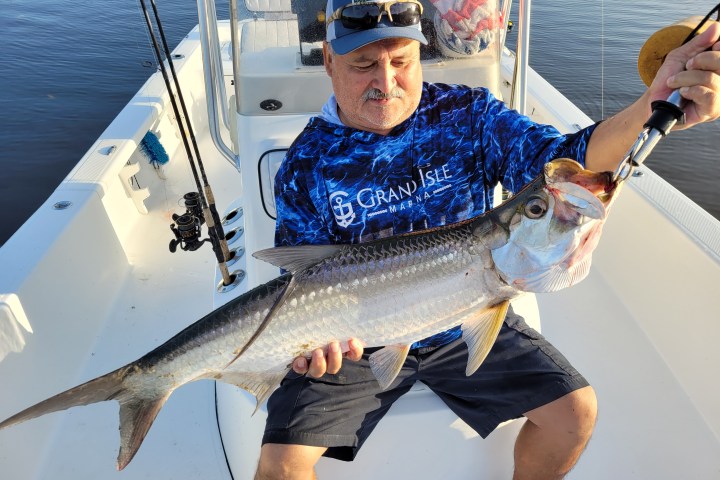 a man holding a fish in the water