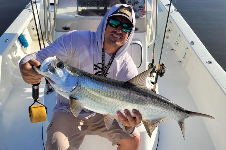 a person holding a fish on a boat