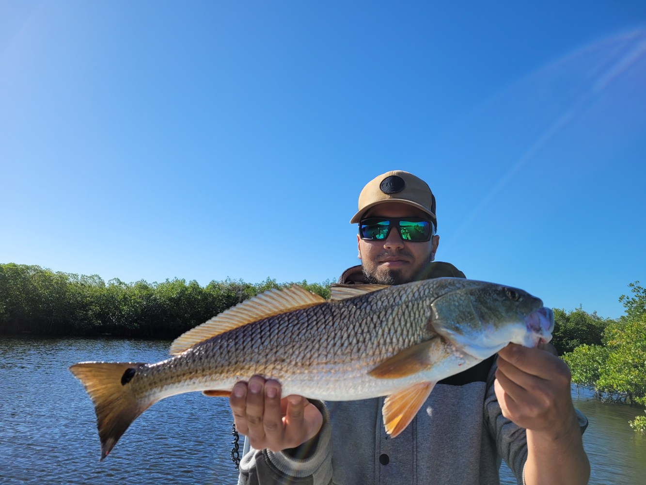a man holding a fish in the water