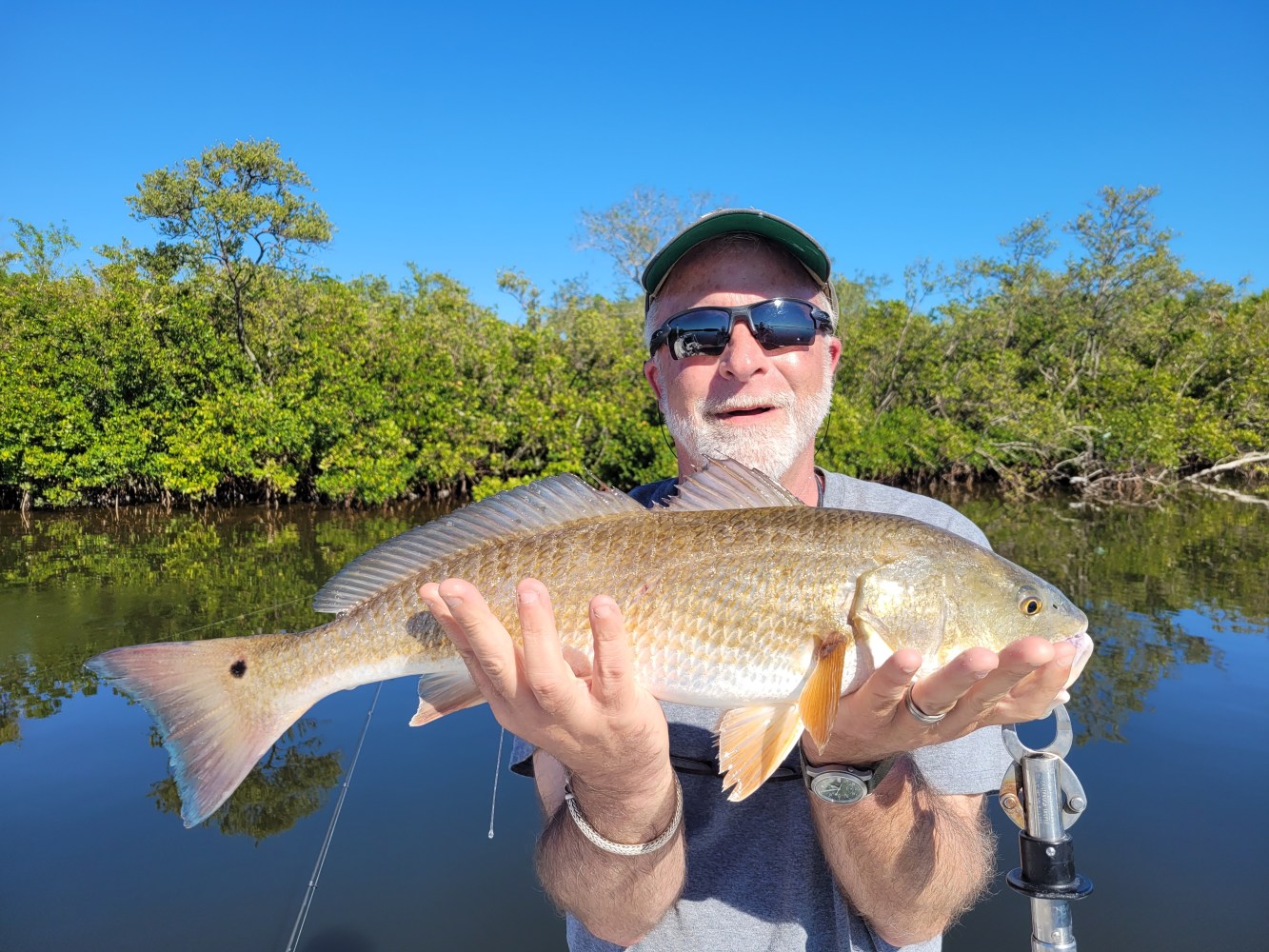 a man holding a fish in the water